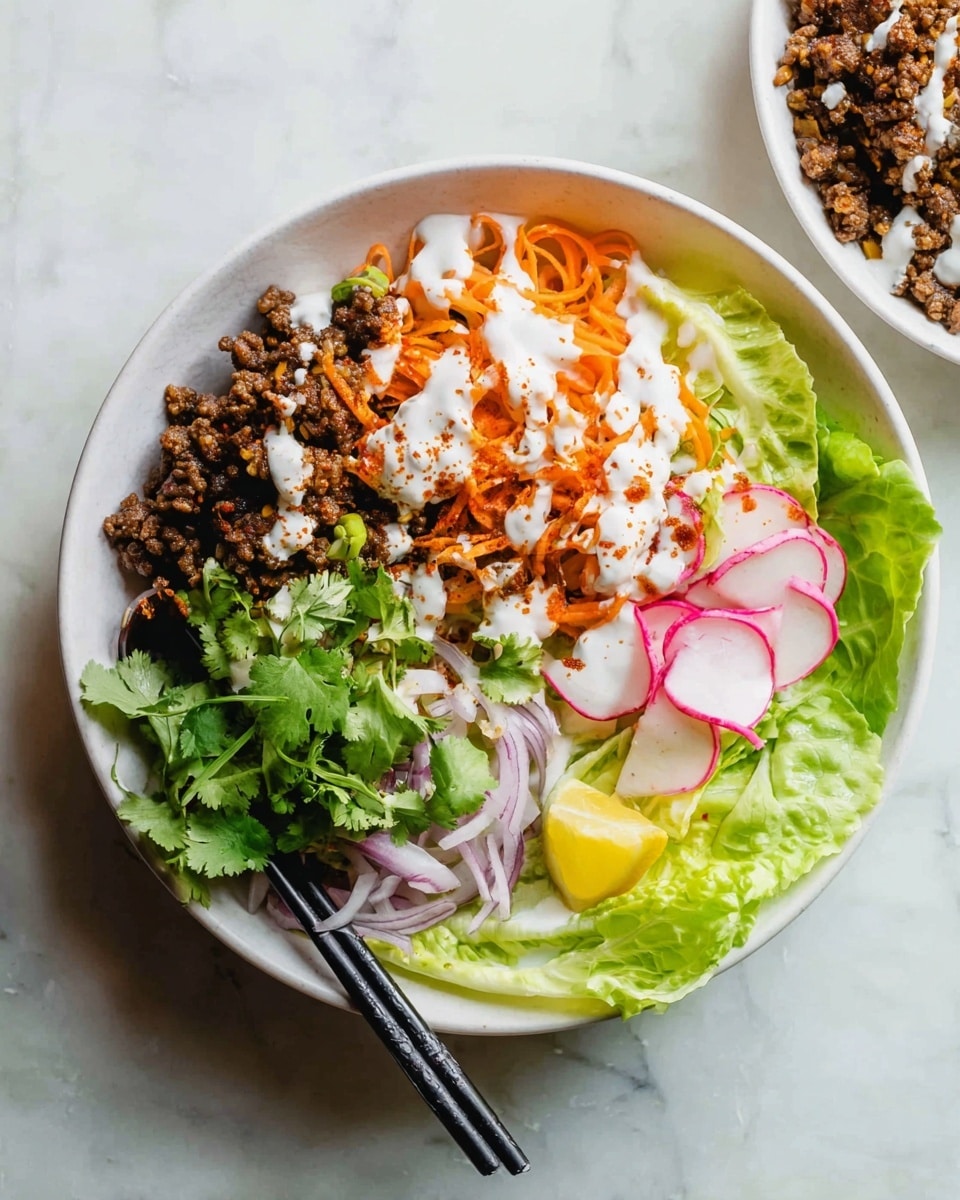 The dish is arranged in a white bowl on a white marbled texture. It has several distinct layers: on the left side, bright green cilantro leaves and light green lettuce wedges form a fresh base; next to it, there are orange sliced carrots topped with a creamy white sauce and a light sprinkle of reddish seasoning. On the right side, there is a layer of dark brown cooked ground meat with radish slices and their green leaves adding a pop of pink and green. Thin, pale pink onion slices are placed near the bottom right, partially under the chopsticks resting on the bowl’s edge. A lime wedge is positioned on the left side, leaning against the lettuce. photo taken with an iphone --ar 4:5 --v 7
