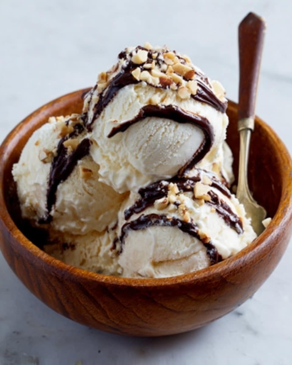 A wooden bowl filled with three scoops of creamy vanilla ice cream. The ice cream is topped with dark chocolate sauce drizzled in uneven lines and sprinkled with small pieces of nuts. A spoon is placed inside the bowl, resting on the side. The bowl sits on a white marbled surface. photo taken with an iphone --ar 4:5 --v 7