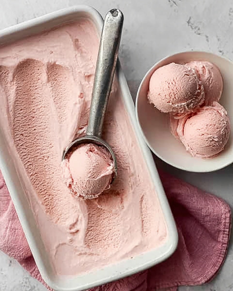 The image shows a white rectangular dish filled with smooth, light pink ice cream that has swirled textures on the surface. Next to it, a white bowl holds three rounded scoops of the same pink ice cream, all resting on a white marbled surface. A silver ice cream scoop, partly filled with ice cream, is placed on the edge of the dish, and a woman's hand is reaching in to hold the scoop. The scene is simple and focused on the creamy texture and soft color of the ice cream. photo taken with an iphone --ar 4:5 --v 7