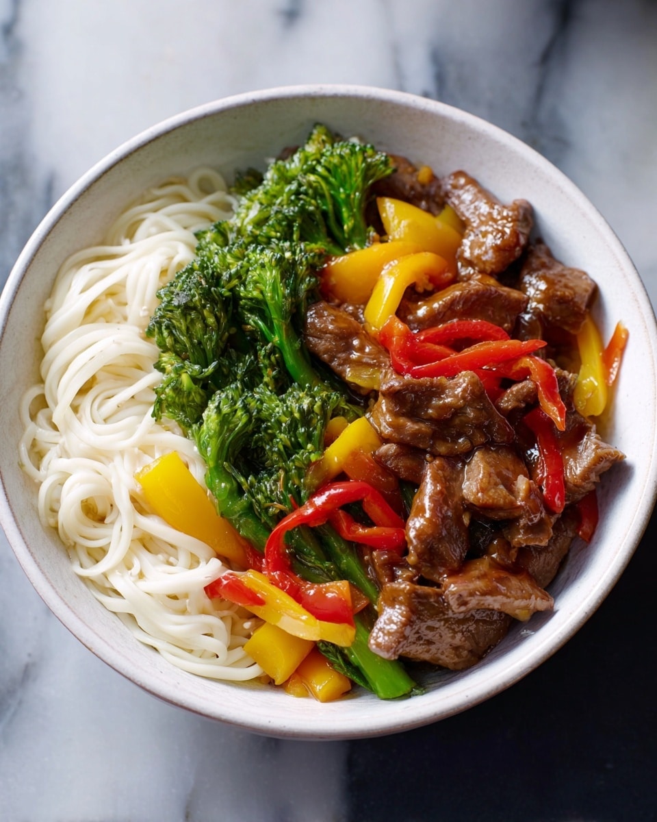 A white bowl with a red inner rim holds food with two main parts: on one side, there are thin, white noodles loosely piled with a smooth texture; on the other side, there is a mix of cooked beef pieces in a shiny brown sauce, bright green broccolini, and chunky bell peppers in red and yellow colors, all mixed together. The food looks fresh and colorful, set against a white marbled surface. photo taken with an iphone --ar 4:5 --v 7