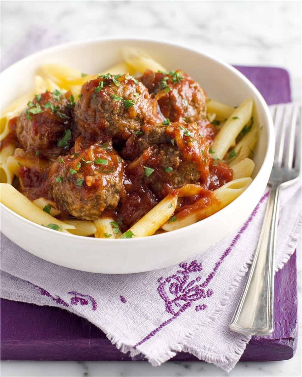 A white bowl filled with penne pasta at the bottom layer, pale yellow and smooth, topped with a thick layer of dark brown meatballs covered in chunky red tomato sauce and some small green herb leaves scattered on top. The bowl rests on a purple square board, which is placed over a white cloth with purple stitching, all set against a white marbled surface. A silver fork lies to the right of the bowl, partially on the cloth. Photo taken with an iphone --ar 4:5 --v 7