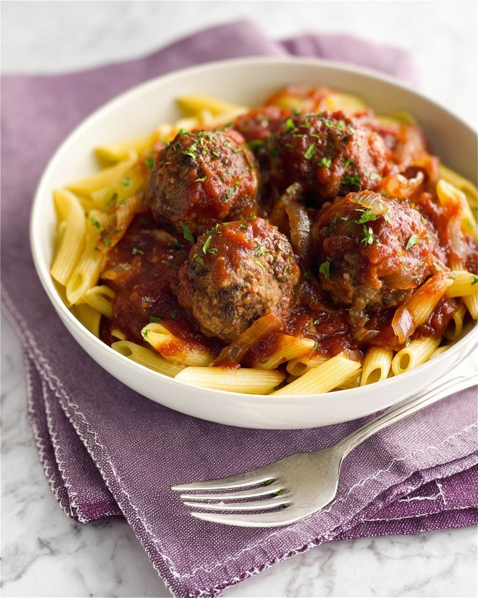 A close-up view of a white bowl filled with light yellow cooked pasta at the bottom layer, topped with five brown meatballs covered in a chunky red tomato sauce with visible pieces of onion and herbs sprinkled on top; the bowl sits on a white cloth with purple embroidery, placed on a small purple wooden board, and a silver fork rests diagonally on the cloth beside the bowl, all set against a white marbled texture background. photo taken with an iphone --ar 4:5 --v 7