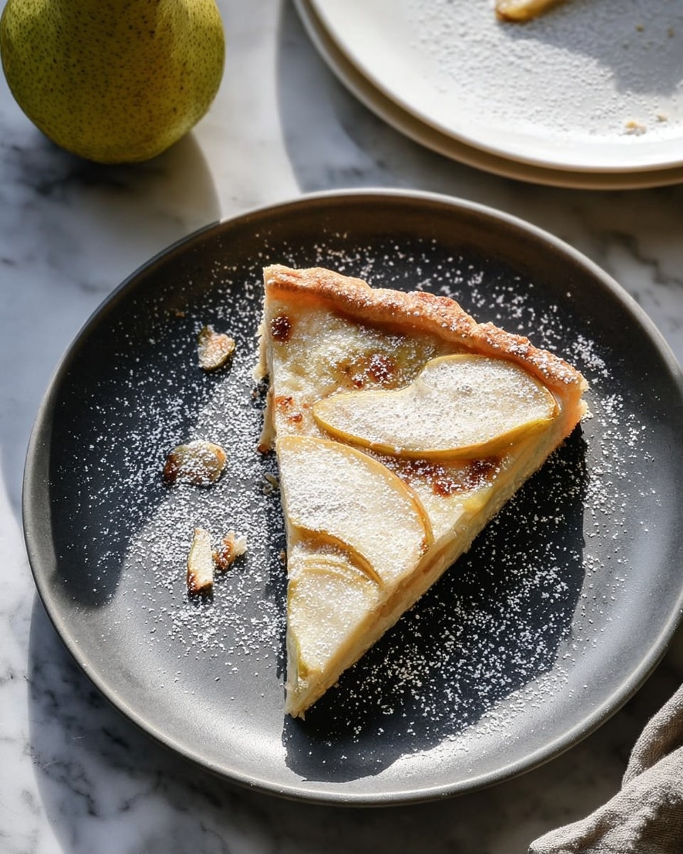 A single slice of flat pear tart is placed on a white plate. The tart has a light golden crust edge and a creamy, slightly browned filling. On top, there are thin, soft slices of cooked pear arranged in a scattered pattern. A light dusting of powdered sugar covers part of the tart and the plate around it. The plate sits on a white marbled textured surface with a whole pear and another white plate partially visible in the background. Natural light casts soft shadows, adding depth to the scene. Photo taken with an iphone --ar 4:5 --v 7
