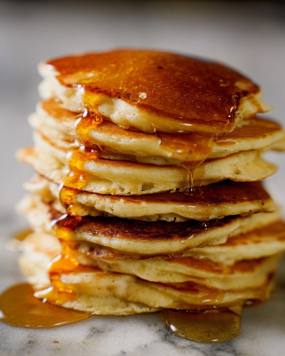 A tall stack of eight fluffy pancakes sits centered, each pancake light golden brown with slightly uneven edges showing soft texture. Golden syrup is poured generously from the top, flowing down in thick, sticky streams that catch the light as they drip over the sides. The background and surface have a white marbled texture. Photo taken with an iphone --ar 4:5 --v 7