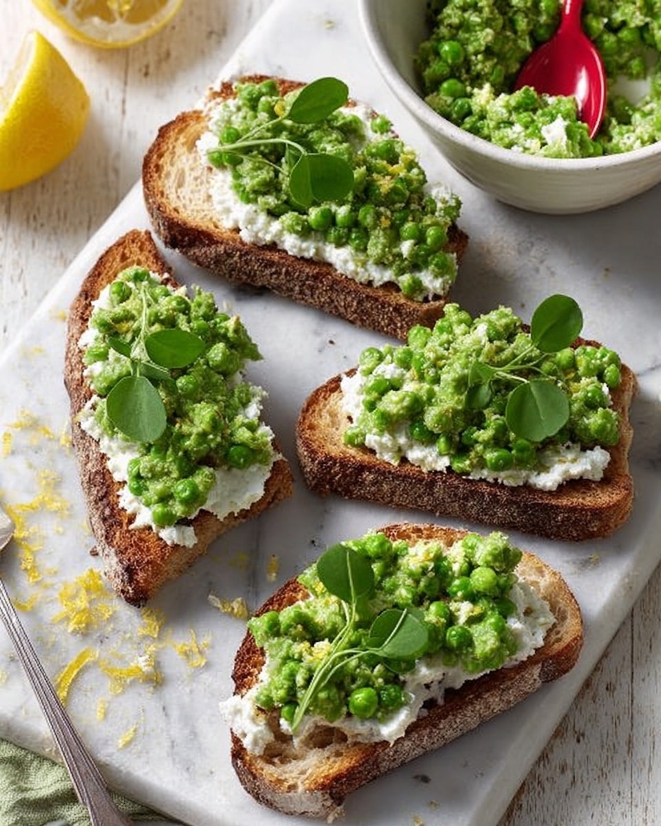 Four pieces of toasted brown bread are arranged on a white marbled surface, each slice topped first with a thick, creamy white spread, followed by a chunky bright green pea mash, and finished with fresh green pea shoots on top. To the left, part of a yellow lemon and its zest are visible, while in the background, a white bowl with a red spoon holds more pea mash. The overall scene is bright and fresh with natural lighting. Photo taken with an iphone --ar 4:5 --v 7