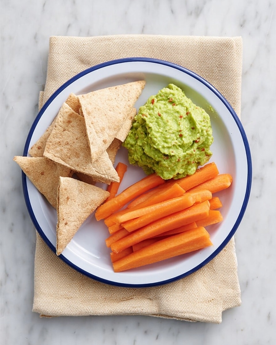 A white plate with a blue rim holds three different foods arranged in a simple layout: on the left, there are six triangular pieces of soft brown pita bread stacked slightly overlapping; in the center bottom, there is a rough-textured dollop of bright green guacamole with small bits of red chili visible; on the right, a neat row of fresh, orange carrot sticks, cut to similar lengths, stands out against the other colors. The plate rests on a brown paper bag with handles, placed on a white marbled surface. Photo taken with an iphone --ar 4:5 --v 7