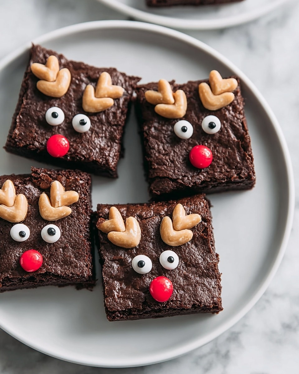 A white plate holds five square chocolate brownies, each decorated to look like a reindeer face. Each brownie shows a moist, slightly textured dark brown base layer. On top, two white candy eyes with black centers sit near the upper middle. Just below the eyes, a round red candy forms the nose. Two small light beige pretzels are placed at the top edge of each brownie to resemble antlers. The plate rests on a white marbled surface. photo taken with an iphone --ar 4:5 --v 7
