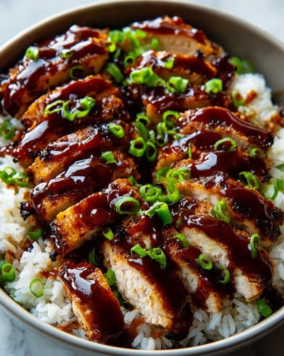 A close-up of a white bowl filled with a base layer of white rice with a soft texture. On top, there are several thick slices of grilled chicken coated in a shiny dark brown sauce. The sauce drips slightly over the chicken and rice. Scattered on the chicken are small pieces of bright green chopped scallions that add color and freshness. The bowl sits on a white marbled surface. photo taken with an iphone --ar 4:5 --v 7