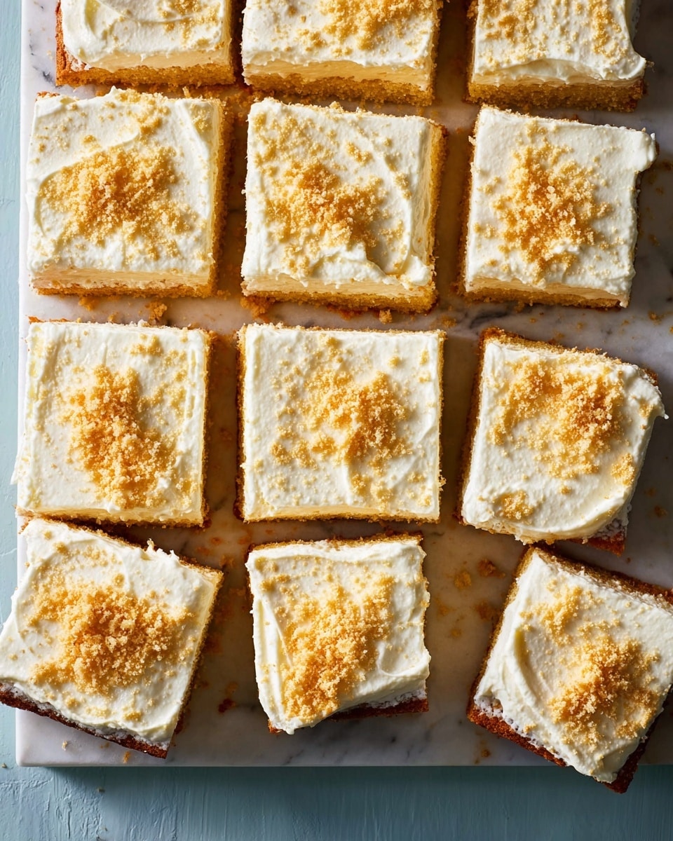 A rectangular cake cut into 12 square pieces is shown from above on a white marbled surface. Each piece has two visible layers: a thick, golden-brown base layer with a slightly rough texture, and a creamy white top layer spread unevenly over the base. The top is sprinkled generously with fine, light brown crumbs that add a crumbly texture. The pieces are closely placed with small gaps between them, and some crumbs are scattered around the edges. The contrast between the golden cake and white frosting is clear, with the crumbs adding a textured finish to the smooth top. photo taken with an iphone --ar 4:5 --v 7