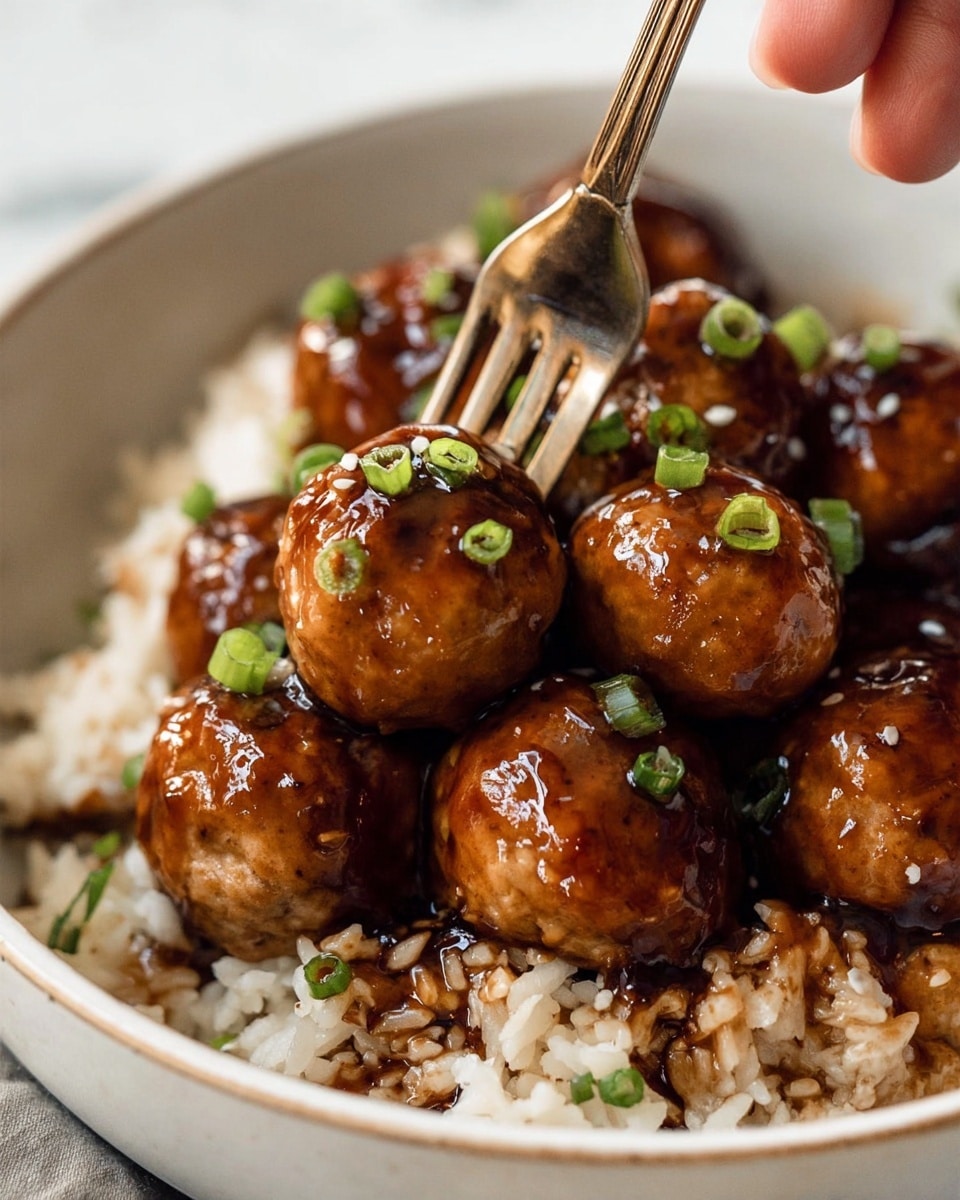 The image shows a close-up of a white bowl filled with a dish of glossy, brown glazed meatballs, each topped with small green chopped onions. The meatballs sit on a bed of cooked white rice mixed with dark brown sauce, creating a mix of light and dark textures. A metallic fork held by a woman's hand is piercing one meatball near the center of the bowl. The background is a white marbled texture. photo taken with an iphone --ar 4:5 --v 7